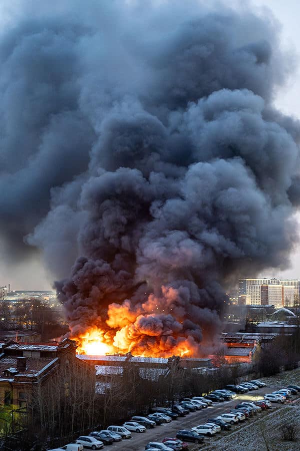 Large industrial fire caused by combustible dusts explosion producing dense black smoke