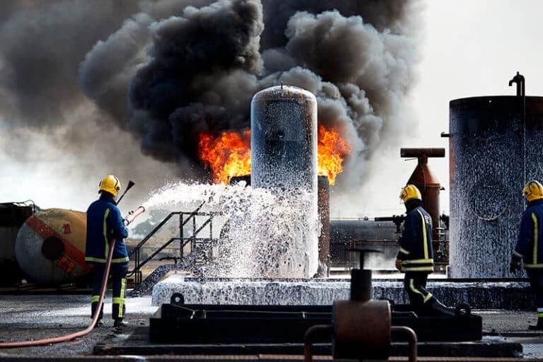 Industrial workers conducting explosion testing for dust, gas, and vapor hazards to collect traceable fire and explosion data