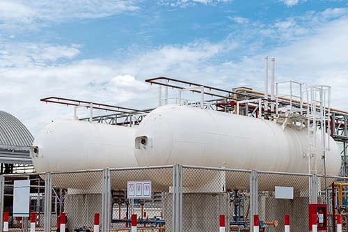 Industrial storage tanks in a fenced facility demonstrating the importance of mechanical integrity in process safety.