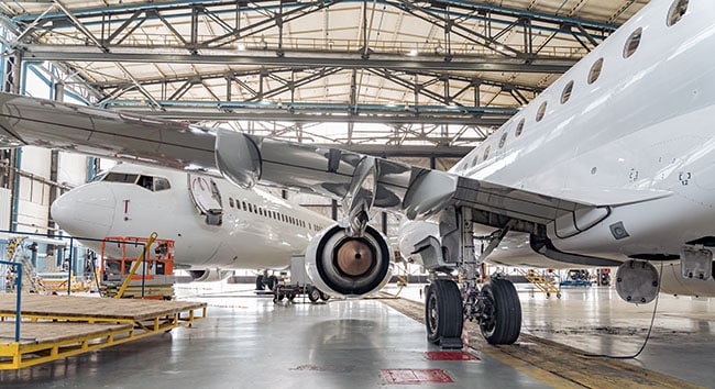 Aerospace process safety—aircraft in hangar with hazard reviews, PHA revalidations, and compliance solutions.