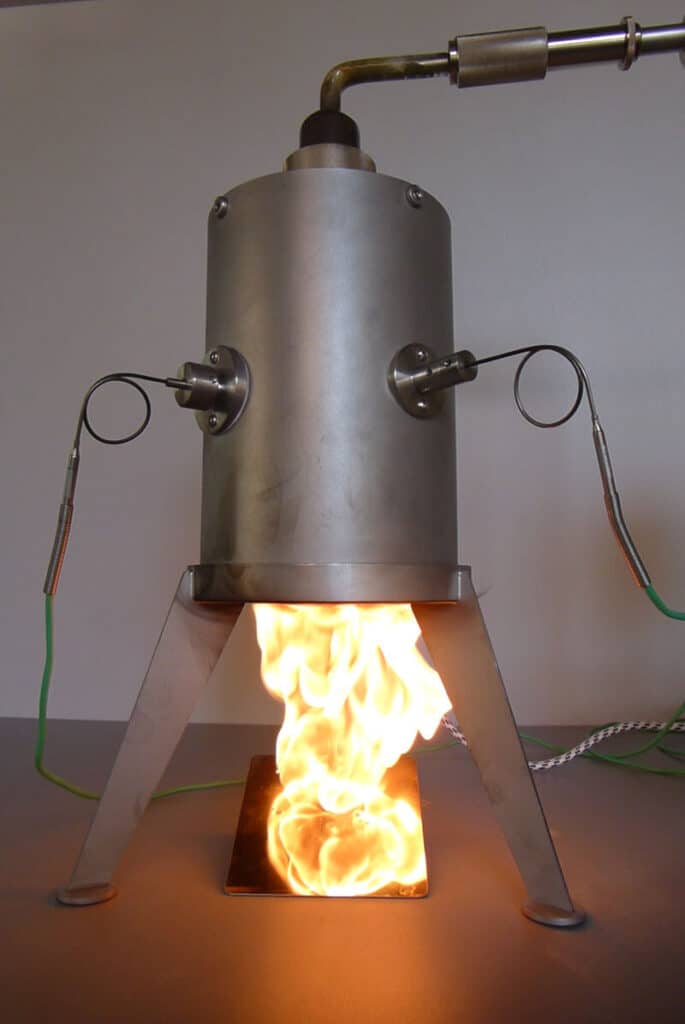Minimum Ignition Temperature (MIT) test apparatus measuring dust ignition risk with visible flame