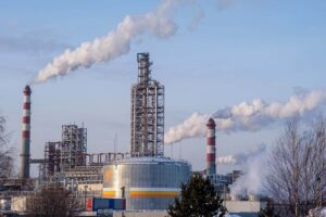 Industrial plant with chimneys emitting smoke, representing process safety management in manufacturing facilities